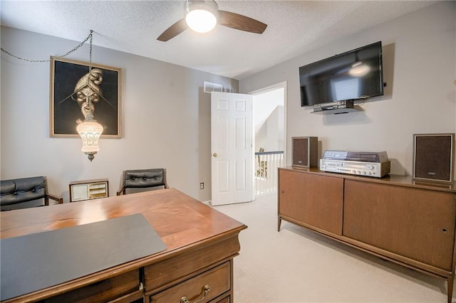 office space featuring ceiling fan, light carpet, and a textured ceiling