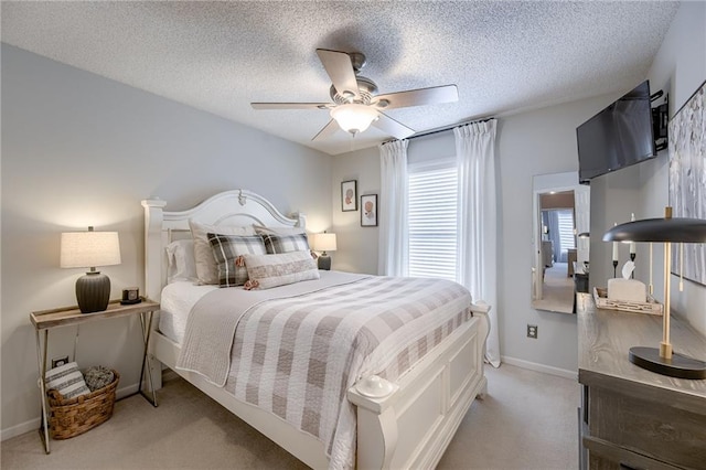 bedroom featuring light carpet, a textured ceiling, and ceiling fan