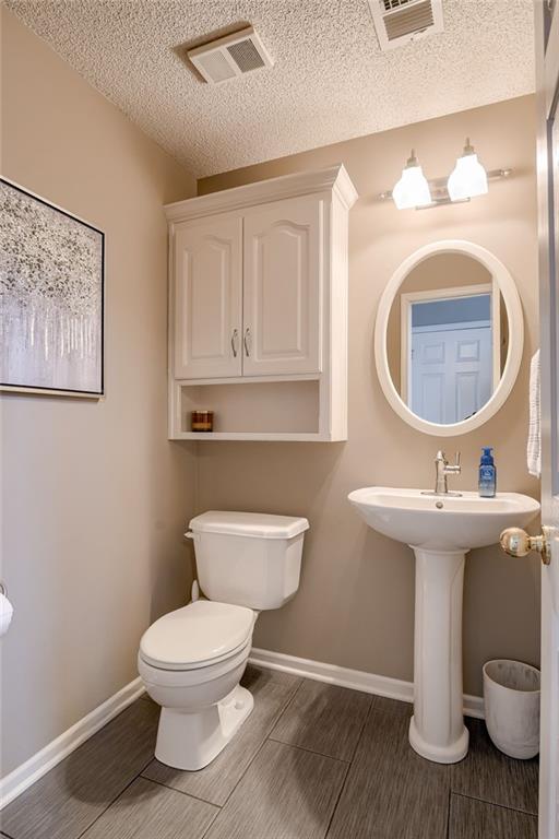 bathroom with a textured ceiling and toilet