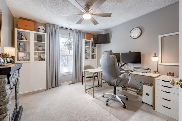 office featuring light carpet, a fireplace, plenty of natural light, and a textured ceiling