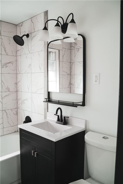 full bathroom with vanity, toilet, and tiled shower / bath