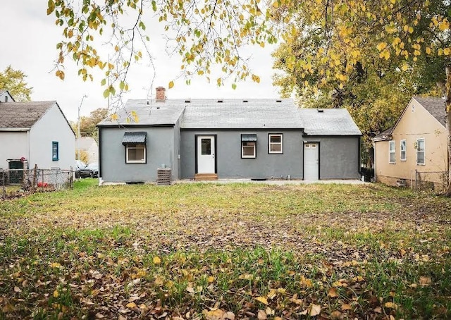 back of property with cooling unit and a lawn