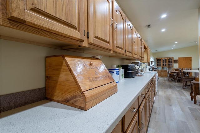 kitchen featuring lofted ceiling, sink, wooden counters, and light wood-type flooring