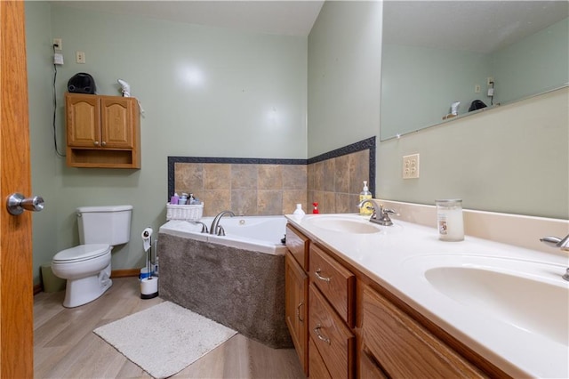 bathroom with vanity, toilet, hardwood / wood-style floors, and tiled tub