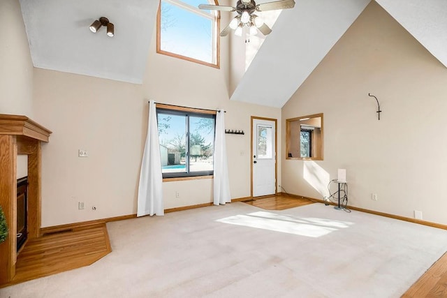 foyer with hardwood / wood-style flooring, a towering ceiling, and ceiling fan