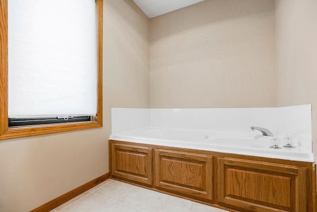 bathroom with a washtub and tile patterned flooring