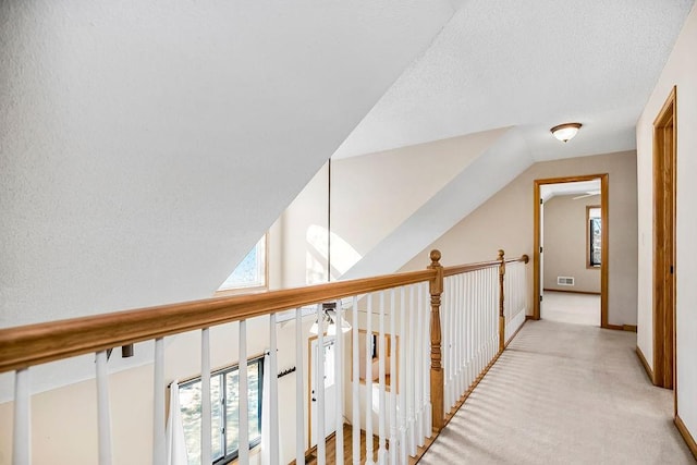 hallway featuring light carpet and lofted ceiling