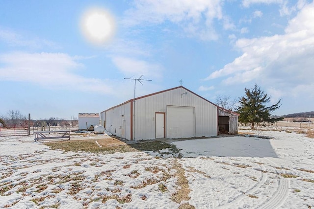 snow covered structure featuring a garage