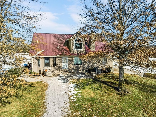 cape cod house featuring a front yard