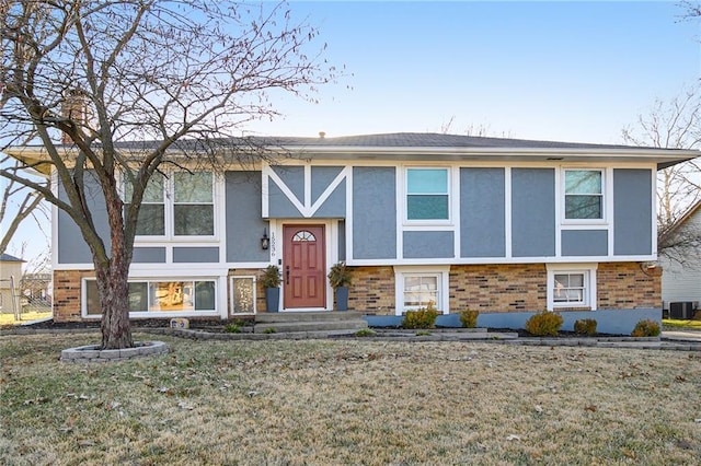 raised ranch featuring a front yard and central AC unit