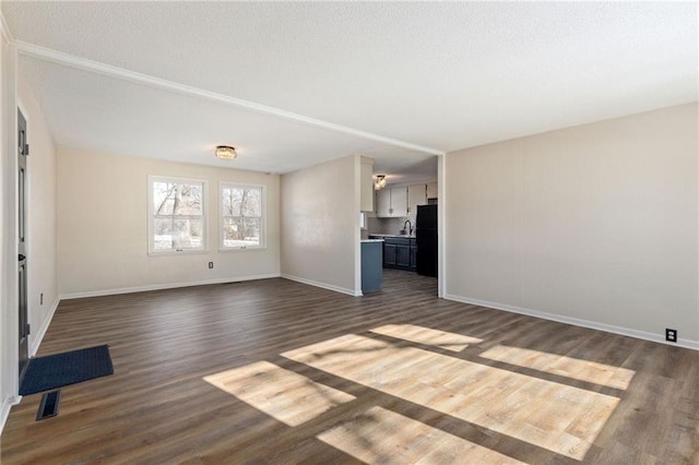 unfurnished living room with dark wood-type flooring