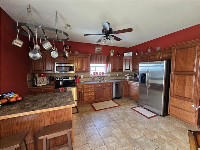 kitchen with sink, backsplash, ceiling fan, kitchen peninsula, and stainless steel appliances