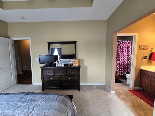 bedroom with light carpet and ensuite bathroom