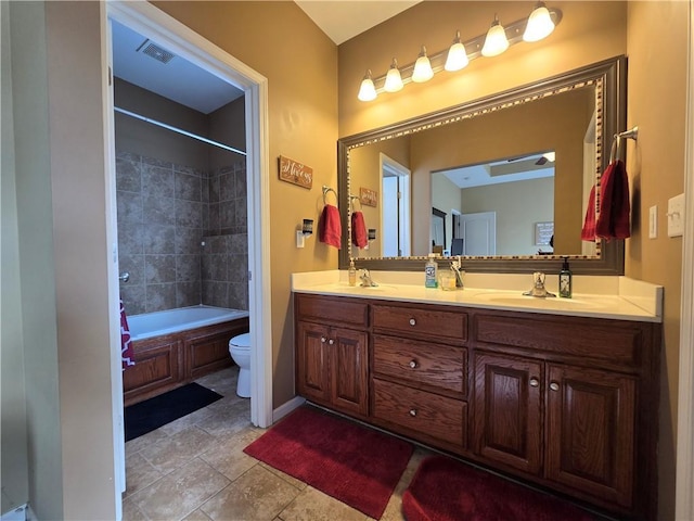 full bathroom featuring vanity, tiled shower / bath, tile patterned floors, and toilet