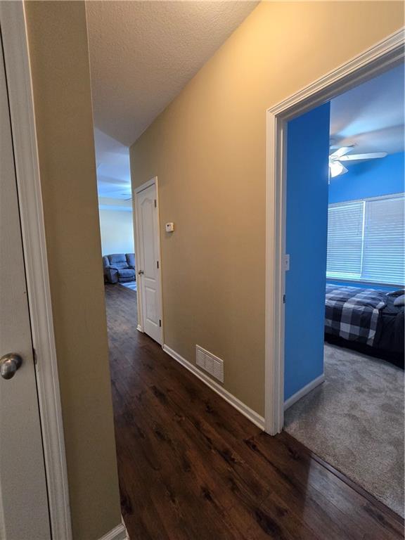 hallway featuring dark hardwood / wood-style floors and vaulted ceiling