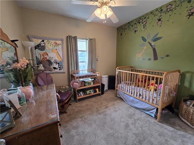 bedroom featuring ceiling fan, carpet, and a crib