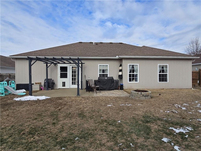 back of property with a pergola, a patio, a playground, and an outdoor fire pit