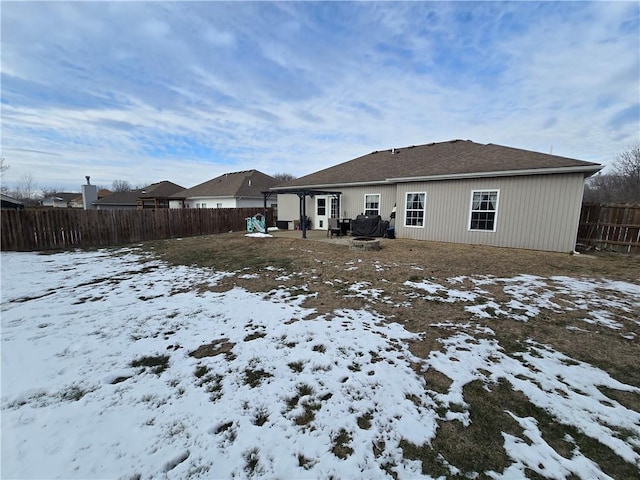 snow covered rear of property featuring a patio