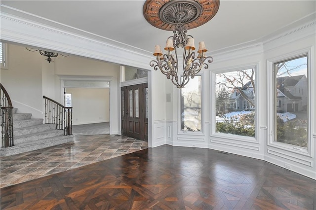 unfurnished dining area featuring an inviting chandelier, dark parquet flooring, and a healthy amount of sunlight