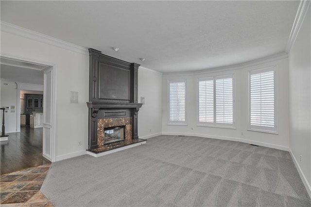 unfurnished living room with crown molding, a fireplace, and carpet floors