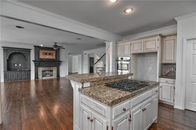 kitchen featuring crown molding, dark wood-type flooring, backsplash, stainless steel appliances, and a kitchen island