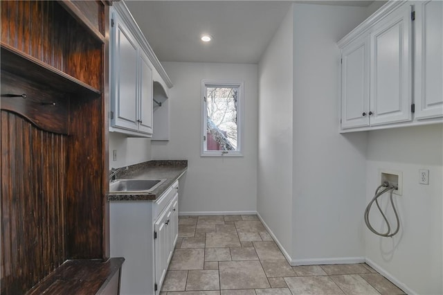 kitchen with light tile patterned floors, sink, and white cabinets