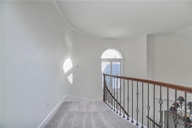 hallway featuring crown molding and light colored carpet