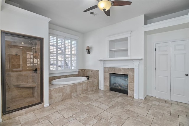 bathroom with a tiled fireplace, built in features, independent shower and bath, and ceiling fan