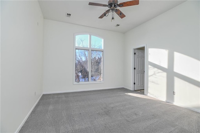 spare room with ceiling fan and dark colored carpet