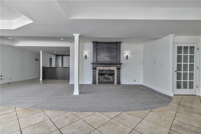 unfurnished living room with tile patterned flooring and ornate columns