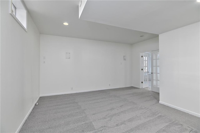 carpeted spare room featuring french doors and a healthy amount of sunlight