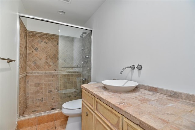 bathroom featuring walk in shower, vanity, toilet, and tile patterned flooring