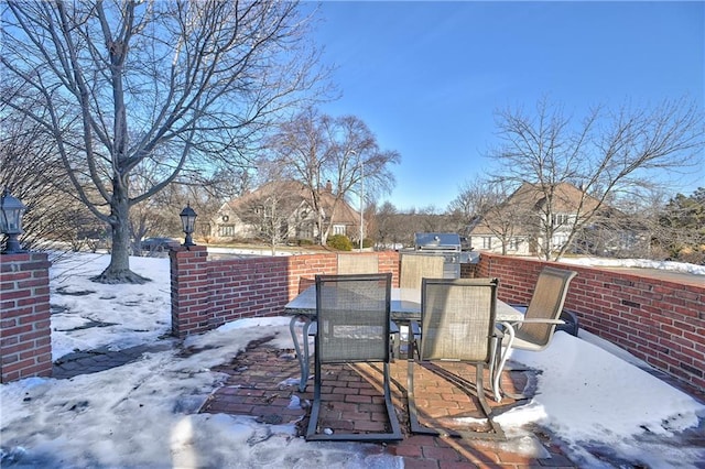 snow covered patio with area for grilling