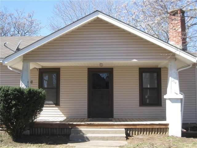 bungalow with a porch and a chimney