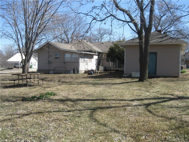 rear view of house featuring a yard