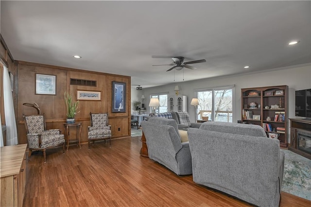 living room with hardwood / wood-style floors, ornamental molding, and ceiling fan