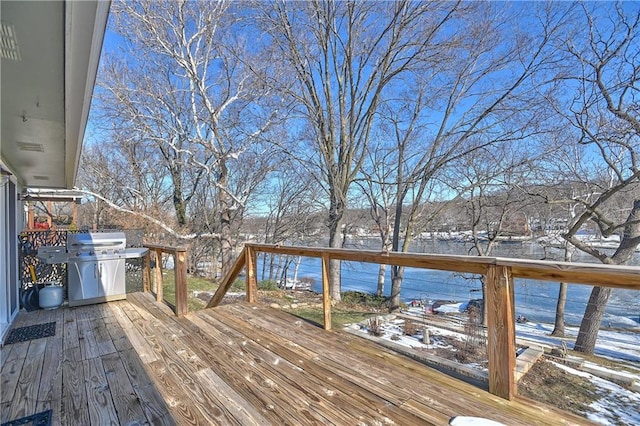 snow covered deck featuring area for grilling and water heater