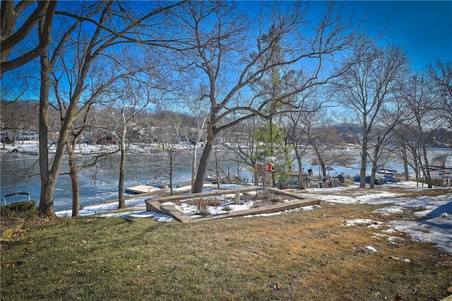 snowy yard featuring a water view