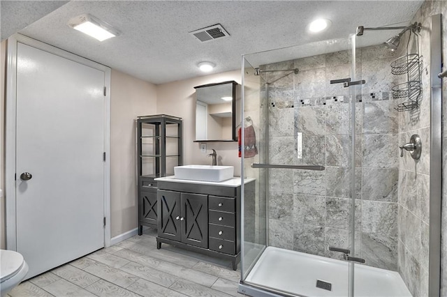 bathroom featuring hardwood / wood-style flooring, vanity, a textured ceiling, toilet, and walk in shower