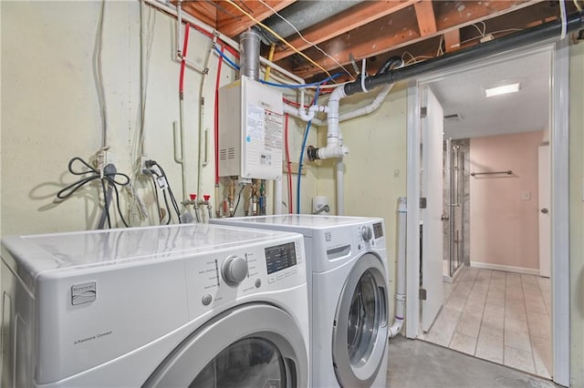 clothes washing area featuring tankless water heater and washer and dryer