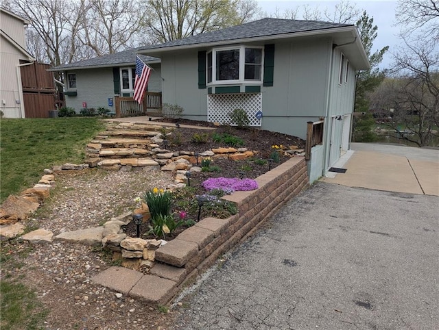 ranch-style home featuring a front lawn, aphalt driveway, and a garage