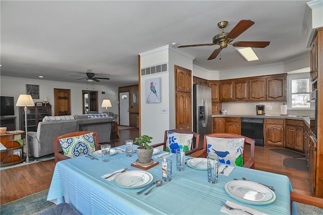 dining area featuring ornamental molding, dark wood-style floors, ceiling fan, and visible vents