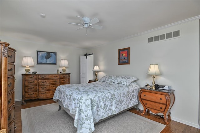 bedroom featuring wood finished floors, visible vents, a ceiling fan, ornamental molding, and baseboards