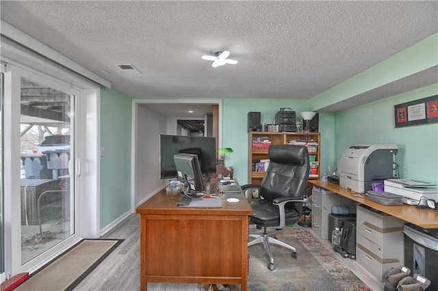 office space featuring visible vents, wood finished floors, and a textured ceiling