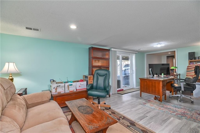 home office featuring recessed lighting, wood finished floors, a textured ceiling, and visible vents