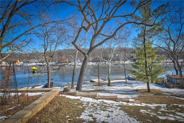 snowy yard featuring a water view