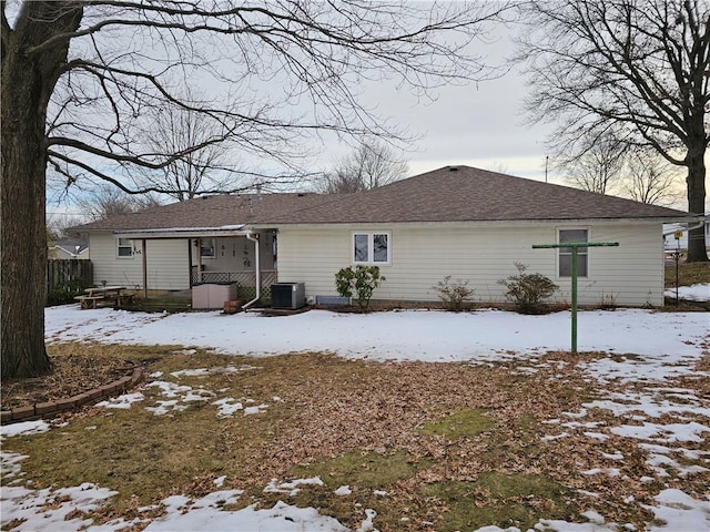 snow covered rear of property with central AC unit