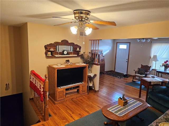 living area with ceiling fan, light wood finished floors, and visible vents