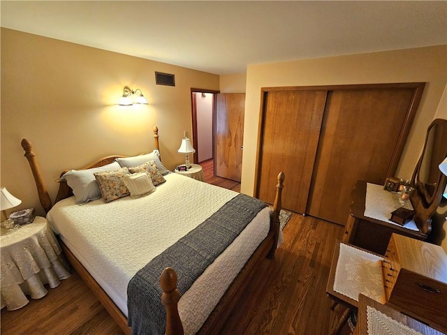 bedroom with a closet, visible vents, and wood finished floors