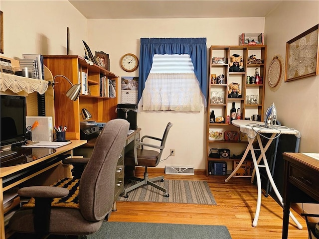 office area featuring wood finished floors and visible vents